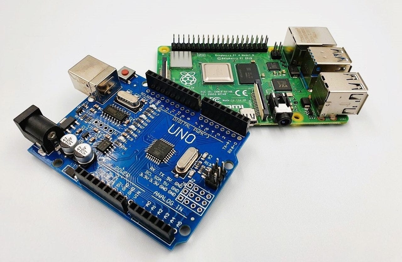 Płytki Arduino Uno i Raspberry Pi 4 obok siebie na białym tle z etykietami