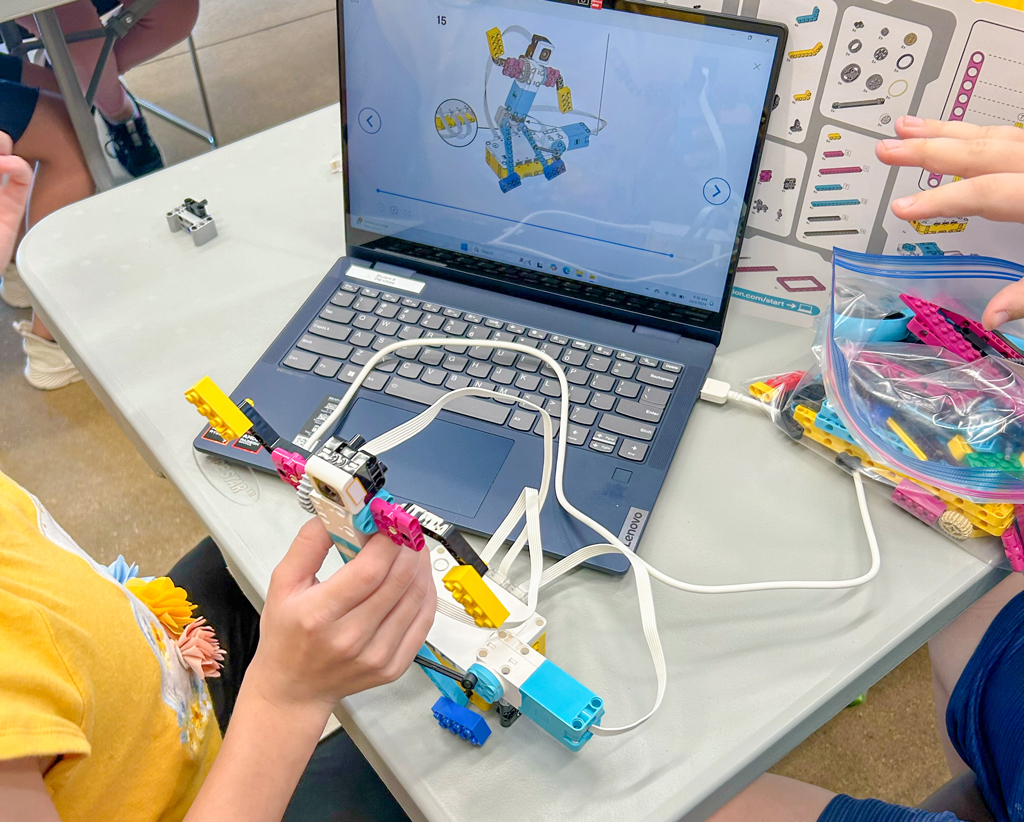 Dzieci sześcioletnie sterują zabawkami robotami za pomocą kolorowych mat programujących